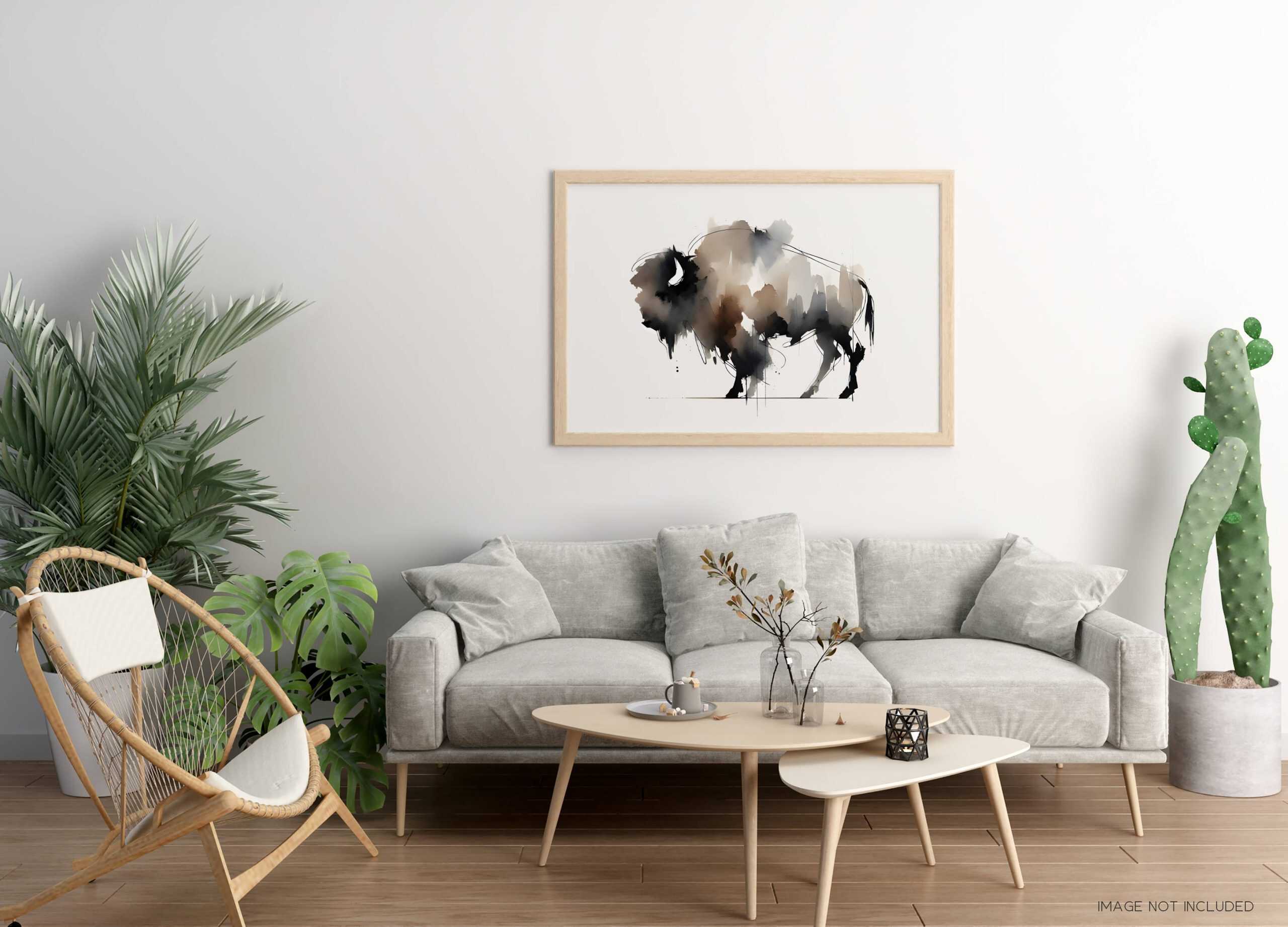 Minimalist living room interior featuring an abstract watercolor bison (buffalo) print in neutral earth tones, framed in light wood and hanging above a contemporary beige sofa with indoor plants.