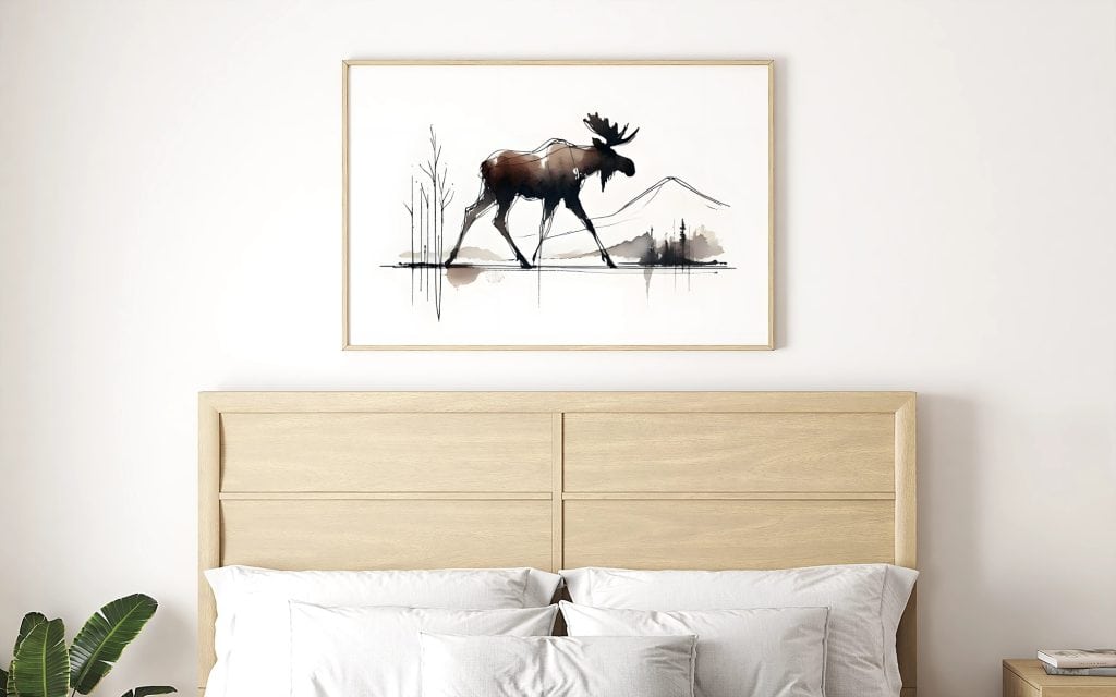 Minimalist bedroom with framed abstract moose watercolor wall art displayed above a light wood bed.