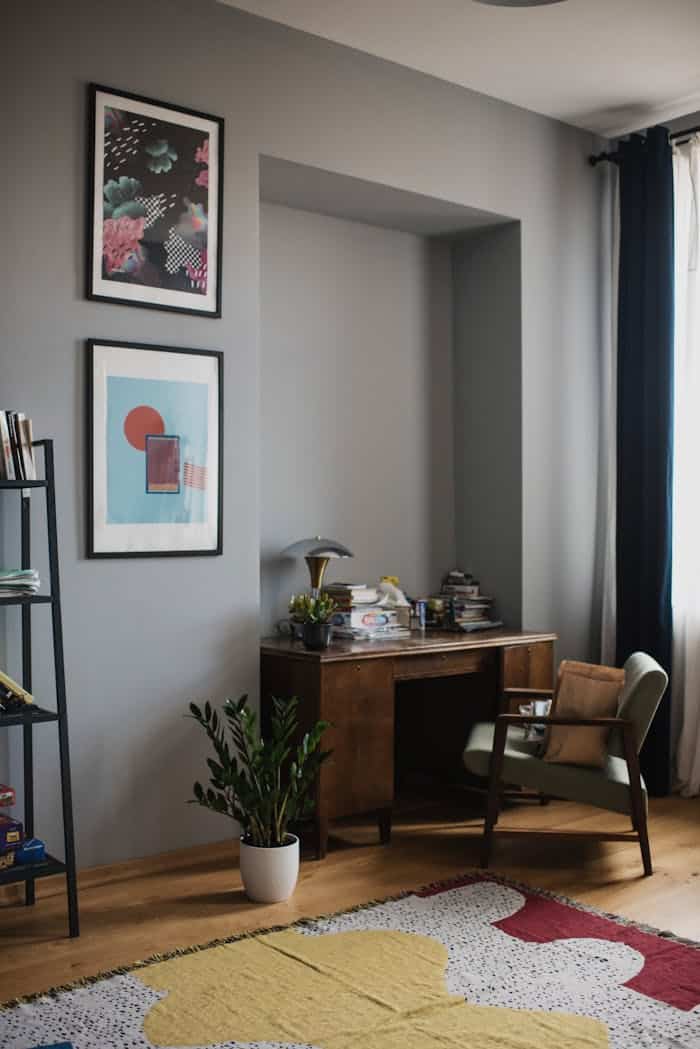 our-journey-02 Cozy home office with vintage desk, artwork, and natural light ambiance.
