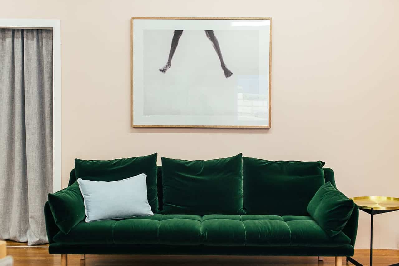experience-img Elegant living room with a green velvet sofa and contemporary decor.